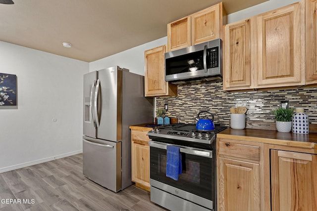 kitchen with light wood-type flooring, appliances with stainless steel finishes, decorative backsplash, and light brown cabinets