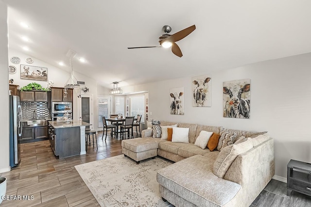 living room featuring vaulted ceiling, ceiling fan, and sink