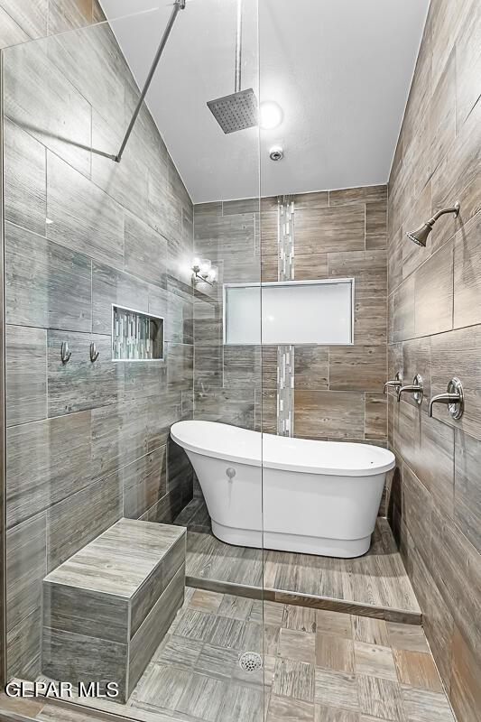 bathroom featuring tile walls and separate shower and tub