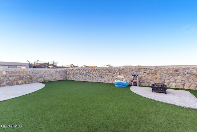 view of yard featuring a patio and a fire pit