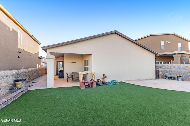 rear view of property featuring a patio area and a yard