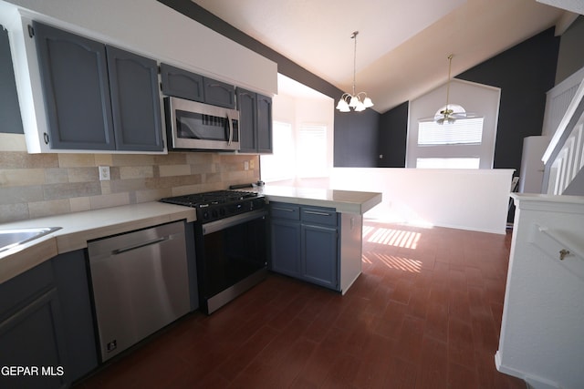 kitchen featuring ceiling fan with notable chandelier, decorative light fixtures, stainless steel appliances, kitchen peninsula, and vaulted ceiling