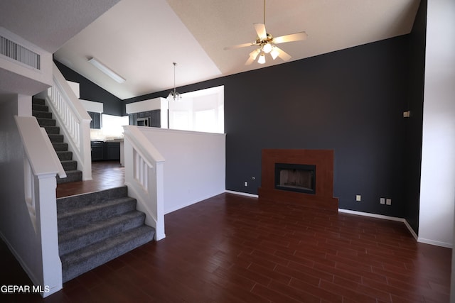 living room featuring high vaulted ceiling, dark wood-type flooring, and ceiling fan with notable chandelier