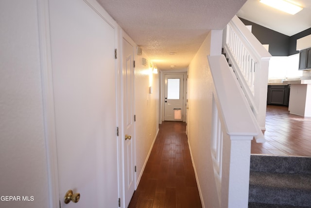 hallway featuring a textured ceiling and dark hardwood / wood-style flooring