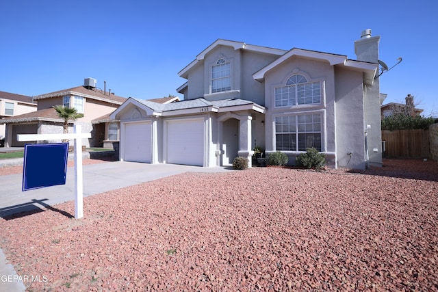 front facade featuring central AC and a garage