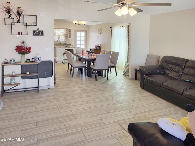 living room featuring ceiling fan with notable chandelier