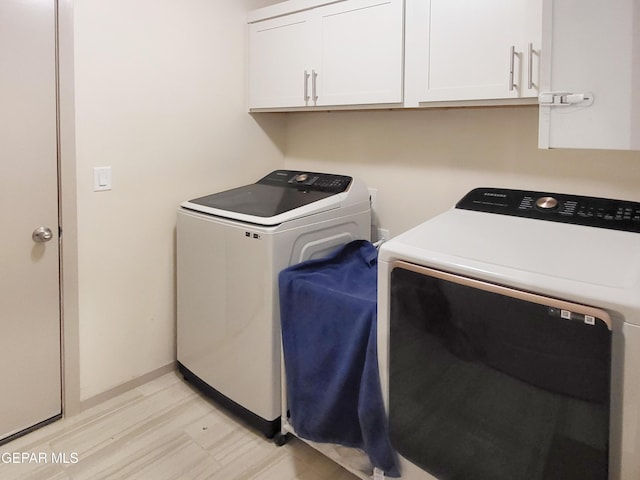 laundry room featuring washing machine and dryer and cabinets