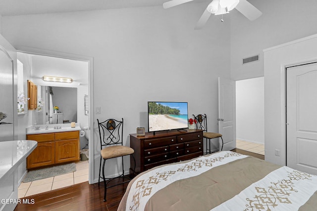 bedroom with visible vents, a ceiling fan, connected bathroom, wood finished floors, and high vaulted ceiling