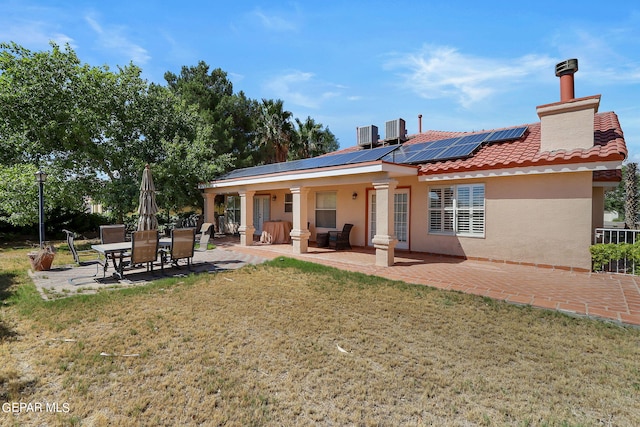 back of house featuring a yard, a patio, stucco siding, cooling unit, and a tiled roof