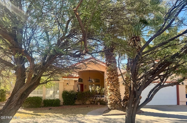 view of front facade with covered porch, driveway, and stucco siding