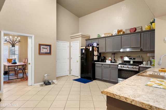 kitchen with a notable chandelier, gray cabinets, sink, black fridge with ice dispenser, and stainless steel gas range