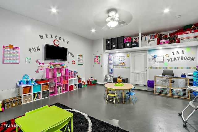 recreation room with ceiling fan and concrete floors