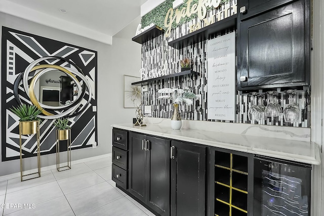 bar featuring light tile patterned floors, wine cooler, and light stone countertops