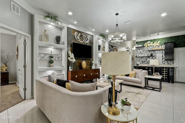 tiled living room featuring indoor bar, built in features, and an inviting chandelier