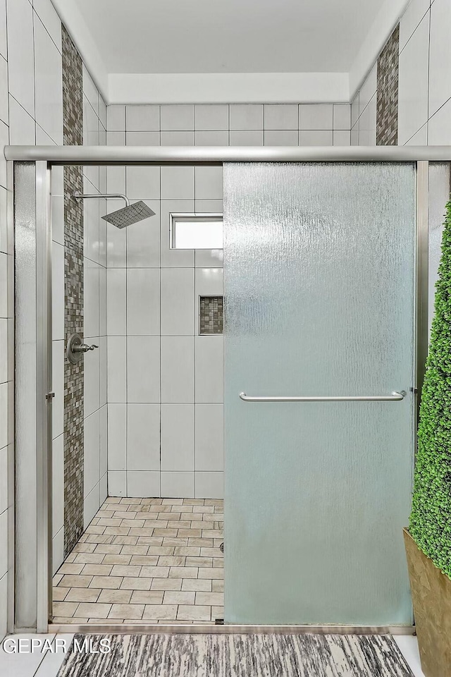 bathroom featuring a shower with shower door