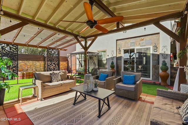 sunroom featuring ceiling fan and lofted ceiling with beams