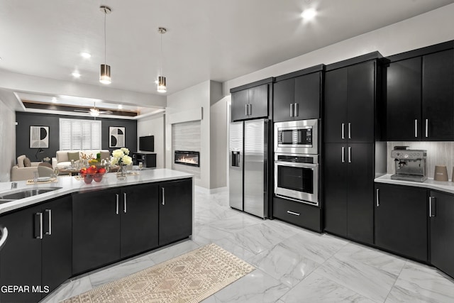 kitchen featuring decorative light fixtures, sink, and appliances with stainless steel finishes