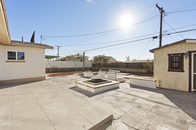 view of patio / terrace with an outdoor fire pit and an outbuilding