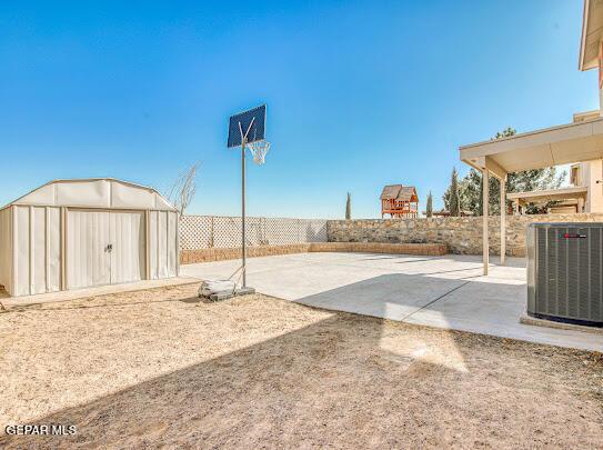 view of patio featuring central AC unit and a storage unit