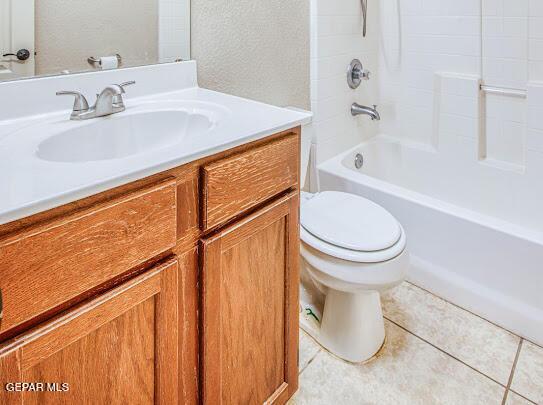 full bathroom with bathtub / shower combination, toilet, vanity, and tile patterned flooring