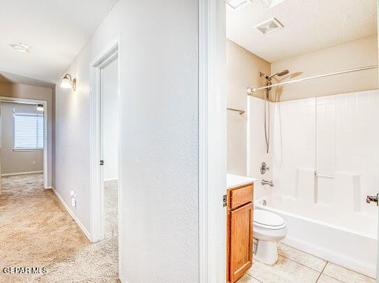 full bathroom featuring toilet, vanity, tile patterned flooring, and shower / bath combination