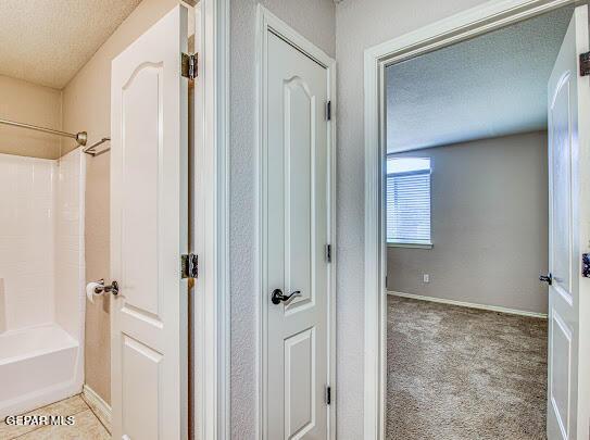 bathroom with shower / bathtub combination and a textured ceiling