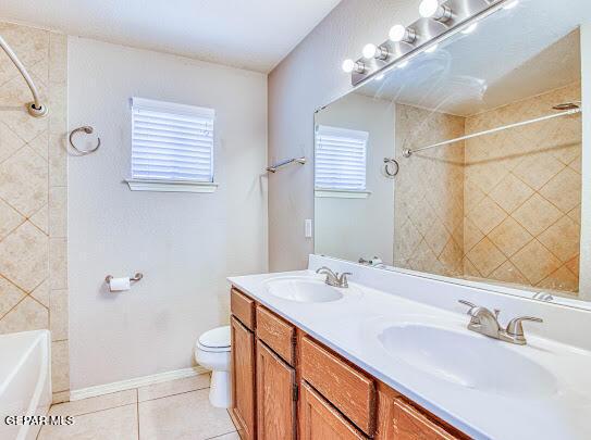 full bathroom featuring toilet, tiled shower / bath, tile patterned floors, and vanity