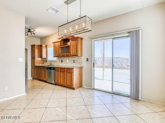 kitchen with light tile patterned floors, tasteful backsplash, dishwasher, pendant lighting, and sink