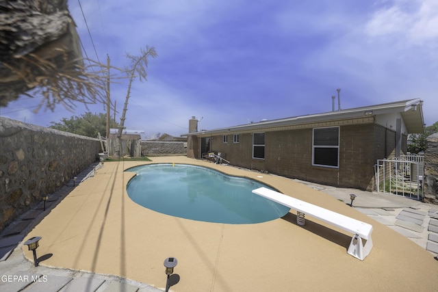 view of pool featuring a patio area and a diving board