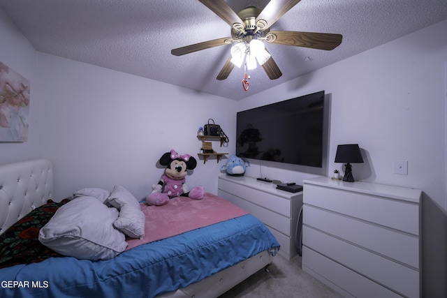 bedroom with ceiling fan, light colored carpet, and a textured ceiling