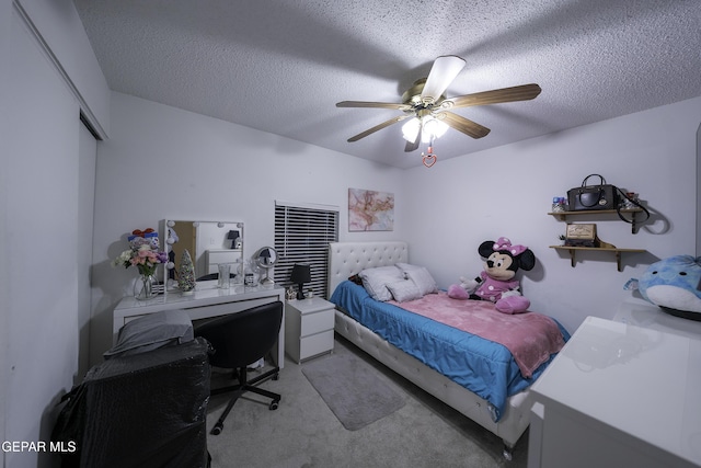 carpeted bedroom with ceiling fan, a textured ceiling, and a closet