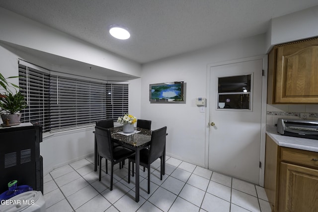 dining area featuring light tile patterned flooring and a textured ceiling