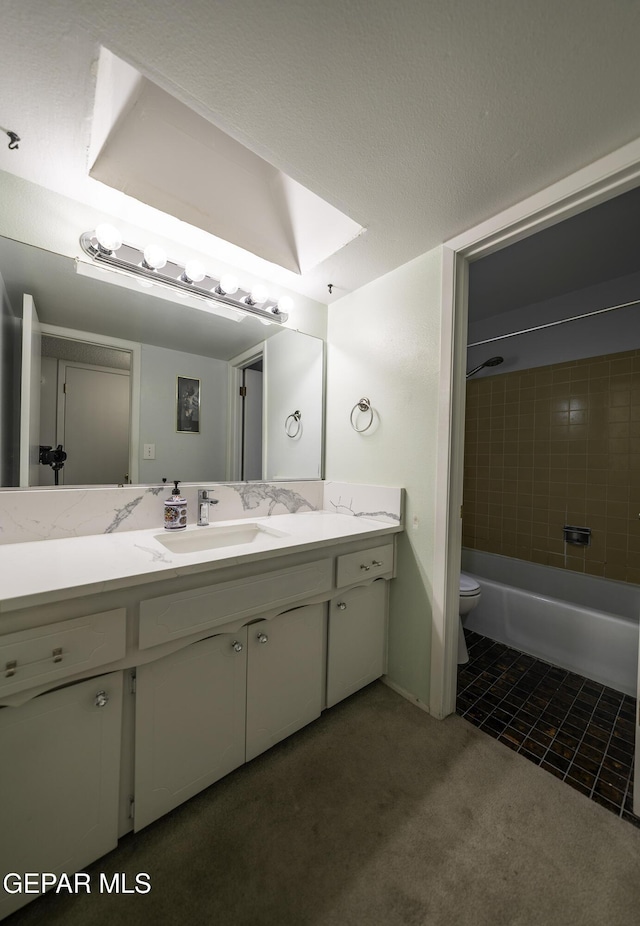 full bathroom with toilet, a skylight, tiled shower / bath, tile patterned flooring, and vanity