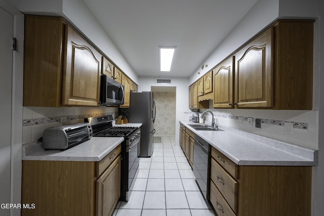 kitchen with light tile patterned floors, sink, backsplash, and black appliances