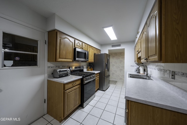 kitchen featuring light tile patterned floors, decorative backsplash, sink, and stainless steel appliances