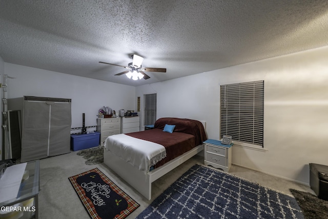 carpeted bedroom featuring a textured ceiling and ceiling fan