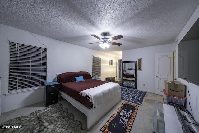 bedroom with a textured ceiling, ceiling fan, and carpet flooring