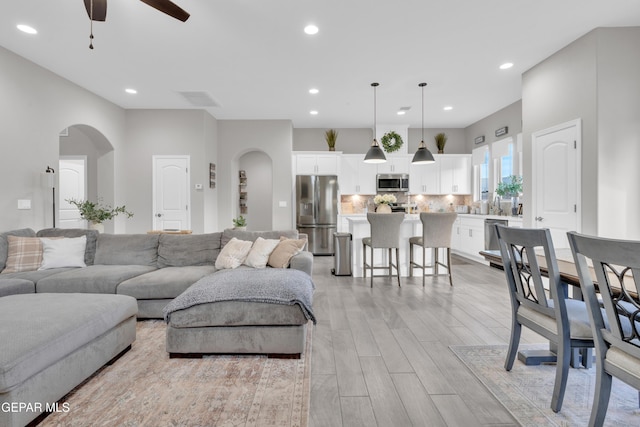 living room with light hardwood / wood-style floors and ceiling fan