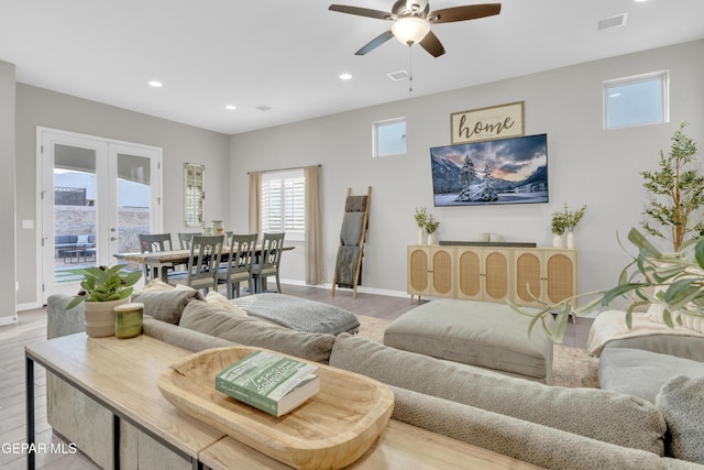 living room with french doors, ceiling fan, and light hardwood / wood-style floors