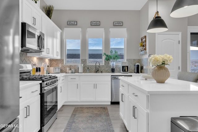 kitchen with backsplash, stainless steel appliances, sink, and white cabinets