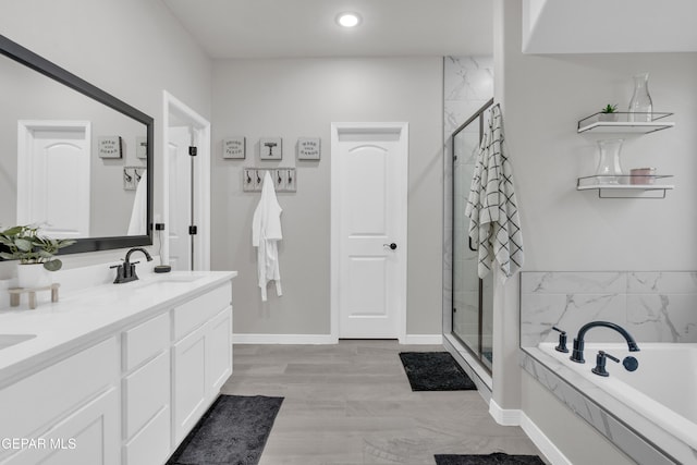 bathroom with wood-type flooring, separate shower and tub, and vanity