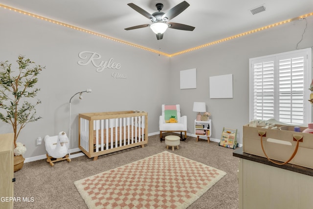 bedroom with a crib, carpet, and ceiling fan