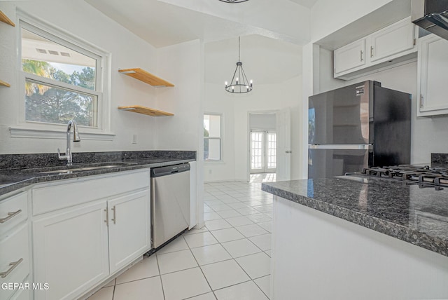 kitchen with pendant lighting, appliances with stainless steel finishes, white cabinetry, sink, and a chandelier