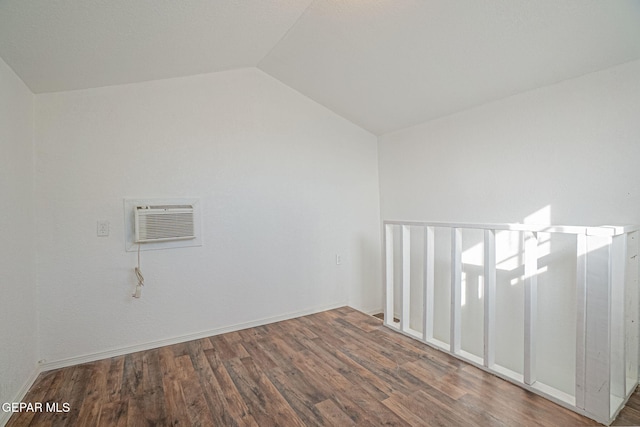 additional living space featuring an AC wall unit, dark hardwood / wood-style floors, and lofted ceiling