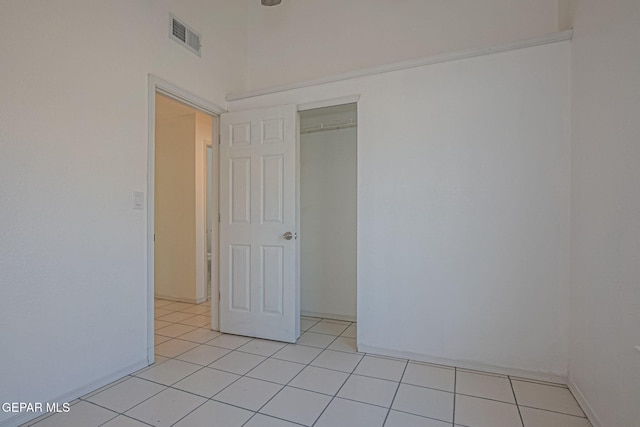 unfurnished bedroom featuring a closet and light tile patterned flooring