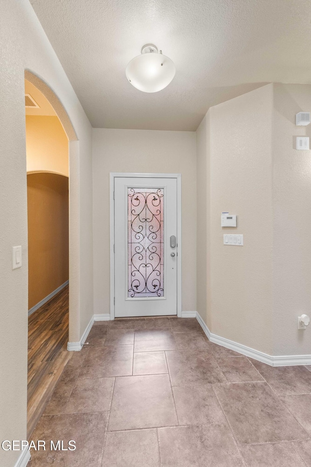 tiled entrance foyer featuring a textured ceiling