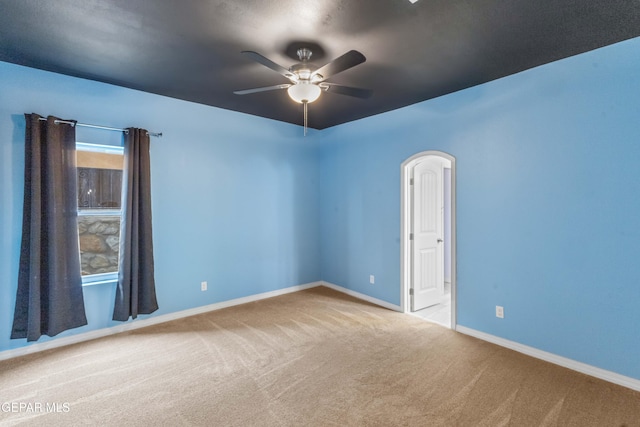 empty room featuring ceiling fan and light carpet