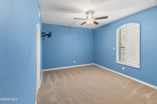 carpeted empty room featuring ceiling fan