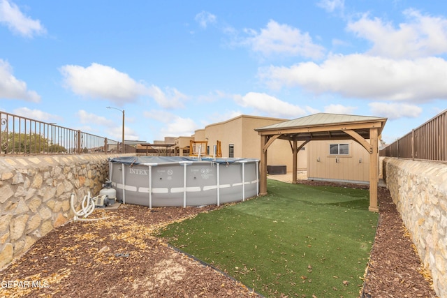 view of yard featuring a covered pool and a gazebo