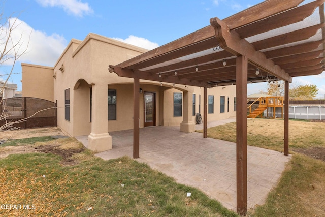 back of house with a playground, a lawn, and a patio